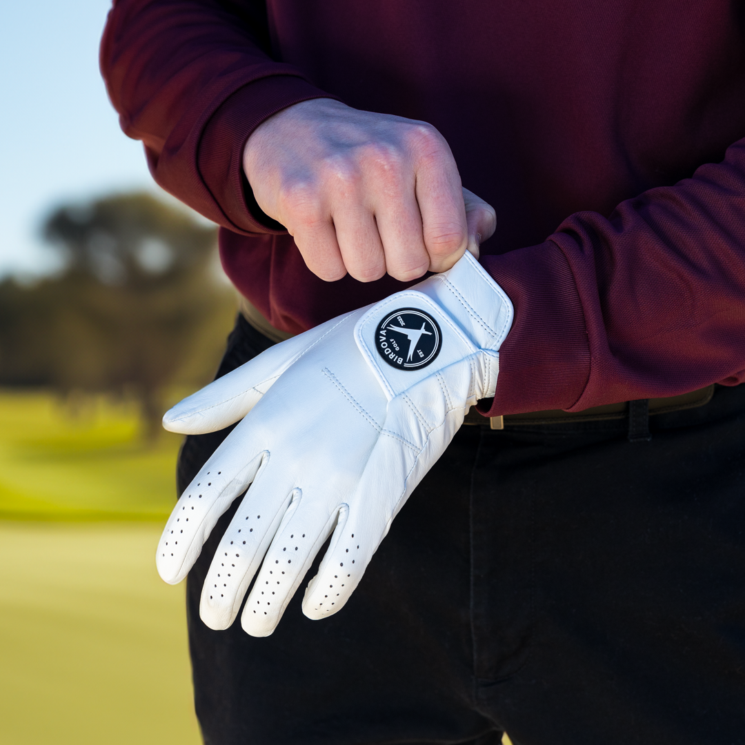 Hand putting on Snowy Owl White Golf Glove by Birdova